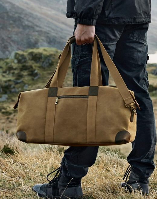 Bolsa de Viaje Heritage en Lona Encerada – 19 L, Cremallera y Bolsillo Frontal – Estilo Clásico Cuero y Latón